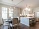 Bright dining room open to the kitchen with a modern chandelier, large windows and beautiful wood floors at 2637 Sidford Aly, Raleigh, NC 27608