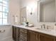 Bright bathroom with double sink vanity, stone countertop, and decorative flowers at 2641 Sidford Aly, Raleigh, NC 27608