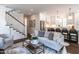 Open-concept living area with a staircase, and a view into a modern kitchen with stainless steel appliances at 2641 Sidford Aly, Raleigh, NC 27608