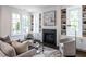 Living room featuring a fireplace with built-in shelving and large windows, creating a cozy and bright atmosphere at 2641 Sidford Aly, Raleigh, NC 27608