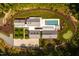 Aerial view of home featuring an in-ground pool, putting green, and circular driveway at 295 Lystra Preserve Dr, Chapel Hill, NC 27517