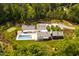 Aerial view of home featuring an in-ground pool, putting green, and U-shaped driveway at 295 Lystra Preserve Dr, Chapel Hill, NC 27517