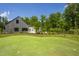 Modern home featuring a putting green surrounded by lush landscaping at 295 Lystra Preserve Dr, Chapel Hill, NC 27517