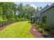 Spacious backyard with green lawn, landscaping and black metal fence at 295 Lystra Preserve Dr, Chapel Hill, NC 27517