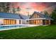Stunning backyard view showcasing a modern pool, lush green lawn, and contemporary architectural design at sunset at 295 Lystra Preserve Dr, Chapel Hill, NC 27517