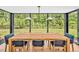 Elegant dining room with a large wooden table and chairs surrounded by floor-to-ceiling windows at 295 Lystra Preserve Dr, Chapel Hill, NC 27517