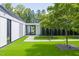 Modern home featuring a contemporary entrance with an artificial lawn, pavers and lush trees at 295 Lystra Preserve Dr, Chapel Hill, NC 27517