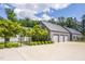 Modern home featuring a three-car garage, black metal fencing and a long concrete driveway at 295 Lystra Preserve Dr, Chapel Hill, NC 27517