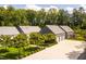 Aerial view of home featuring an oversized driveway, three-car garage, fenced backyard, and lawn at 295 Lystra Preserve Dr, Chapel Hill, NC 27517