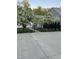Modern black fence with flowering trees along a concrete path showcasing the property's stylish curb appeal at 295 Lystra Preserve Dr, Chapel Hill, NC 27517