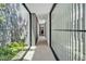 Bright hallway with walls of windows looking out to a garden, leading to a bathroom at 295 Lystra Preserve Dr, Chapel Hill, NC 27517