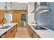 Modern kitchen with white counters, wood cabinets, stainless steel appliances, and tiled backsplash at 295 Lystra Preserve Dr, Chapel Hill, NC 27517
