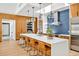 Modern kitchen featuring a large island with seating, custom wood cabinets, and stylish pendant lighting at 295 Lystra Preserve Dr, Chapel Hill, NC 27517