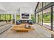 Elegant living room with large windows showcasing the green landscape, fireplace, and stylish furniture at 295 Lystra Preserve Dr, Chapel Hill, NC 27517