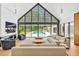 Open living room with soaring windows offers an inviting space with pool view, modern furniture, and fireplace at 295 Lystra Preserve Dr, Chapel Hill, NC 27517