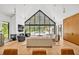 Bright living room features a soaring A-frame window, fireplace, and views of the pool at 295 Lystra Preserve Dr, Chapel Hill, NC 27517