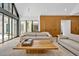Bright living room featuring large windows, light wood floors, and minimalist modern furnishings at 295 Lystra Preserve Dr, Chapel Hill, NC 27517