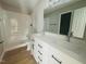 Modern bathroom featuring double sinks, white cabinets, and a shower-tub combo for convenience at 300 Saturn St, Dunn, NC 28334