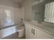Clean bathroom with a shower-tub combo, white toilet, and a vanity with a sink and storage at 300 Saturn St, Dunn, NC 28334