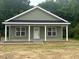 Charming single-story home with a covered front porch, white trim, and light green siding at 300 Saturn St, Dunn, NC 28334