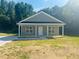 Charming single-story home featuring a covered porch and manicured lawn on a sunny day at 300 Saturn St, Dunn, NC 28334