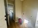Spacious laundry room with an opening looking into the living area with light wood floors and bright light at 300 Saturn St, Dunn, NC 28334
