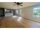 Bright, open-concept living room with wood floors, large windows, and a view of the kitchen at 300 Saturn St, Dunn, NC 28334