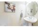 Stylish powder room featuring a pedestal sink, round mirror, and unique cow art at 30155 Pharr, Chapel Hill, NC 27517