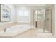 Bright bathroom featuring a soaking tub, walk-in shower, and natural light from the window at 30155 Pharr, Chapel Hill, NC 27517
