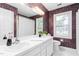 Bathroom featuring double sink vanity, vibrant wallpaper, and framed windows at 3027 Truitt Dr, Burlington, NC 27215