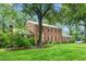 Side view of a well-maintained brick home with lush greenery and mature trees at 3027 Truitt Dr, Burlington, NC 27215