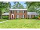 Charming brick home featuring a manicured lawn and vibrant red front door at 3027 Truitt Dr, Burlington, NC 27215