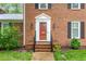 Close-up of a red front door with sidelights and decorative trim at 3027 Truitt Dr, Burlington, NC 27215