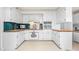 U-shaped kitchen featuring white cabinets, backsplash, and ample counter space for cooking at 3027 Truitt Dr, Burlington, NC 27215