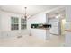 Cozy kitchen and dining area with white cabinets, pendant lighting, and large windows at 3027 Truitt Dr, Burlington, NC 27215