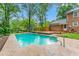 Home has a refreshing pool surrounded by lush greenery and a brick home at 3027 Truitt Dr, Burlington, NC 27215