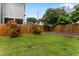 Fenced backyard with green grass and low stone retaining wall with plantings at 305 Georgetown Rd, Raleigh, NC 27608