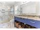 Well-appointed bathroom featuring double sinks, granite counters, tile floors, and a tiled glass shower at 305 Georgetown Rd, Raleigh, NC 27608