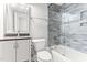 Well-lit bathroom with gray vanity, shower with decorative tile, and updated fixtures for a relaxing experience at 305 Georgetown Rd, Raleigh, NC 27608