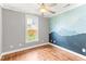 Light filled bedroom featuring an accent wall and hardwood flooring, creating an eye catching space at 305 Georgetown Rd, Raleigh, NC 27608