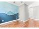 Light filled bedroom featuring an accent wall and hardwood flooring, creating an eye catching space at 305 Georgetown Rd, Raleigh, NC 27608