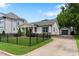 Charming home featuring a covered porch, black fence, and a detached garage with driveway at 305 Georgetown Rd, Raleigh, NC 27608