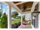 Cozy front porch featuring wood ceiling, a hanging floral arrangement, and a comfortable porch swing at 305 Georgetown Rd, Raleigh, NC 27608