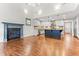 Open-concept living space featuring a fireplace, hardwood floors, and a kitchen with a large island at 305 Georgetown Rd, Raleigh, NC 27608