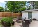 Paver stone patio with built-in stone fire pit, outdoor seating, and detached garage with string lights at 305 Georgetown Rd, Raleigh, NC 27608