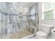 Beautiful glass shower with river rock base, bench, rain head, and stylish gray and white tiling at 305 Georgetown Rd, Raleigh, NC 27608