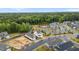 Aerial view of community featuring a pool, tennis court, and clubhouse surrounded by lush greenery at 33 Davidson St, Clayton, NC 27527