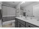 Bathroom featuring a gray vanity with white countertop, neutral tile floor, and a shower/tub with gray and white striped curtain at 33 Davidson St, Clayton, NC 27527