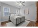 Neutral bedroom featuring a metal bed frame, ceiling fan, and lots of natural light from the windows at 33 Davidson St, Clayton, NC 27527