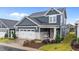 Attractive two-story home featuring a covered front porch, a two-car garage, and colorful flower beds at 33 Davidson St, Clayton, NC 27527